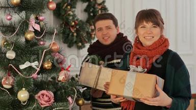 一对美丽的年轻夫妇在<strong>新年</strong>树附近相爱，送给观众<strong>礼</strong>物。 圣诞节和<strong>新年</strong>主题。